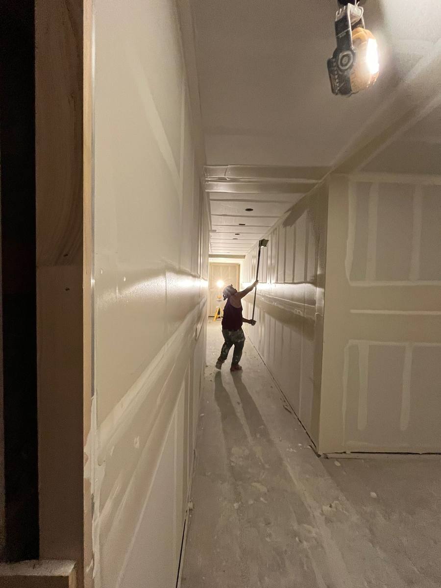 Strong Finish Drywall crew finishing hallway drywall in a new construction home